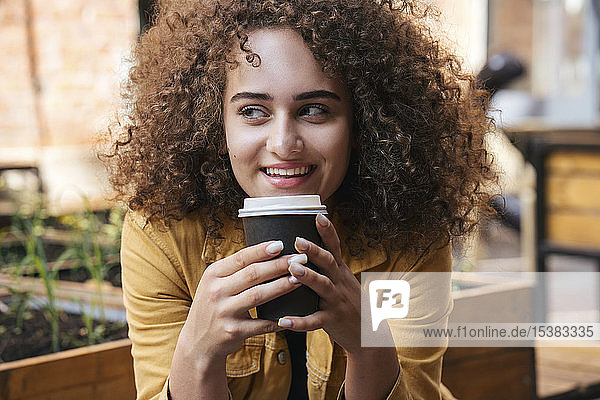 Porträt einer lächelnden Teenagerin  die Kaffee trinkt  um ins Freie zu gehen