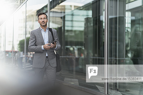 Portrait of businessman with cell phone on the go