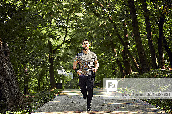 Sportlicher Mann rennt auf Waldweg