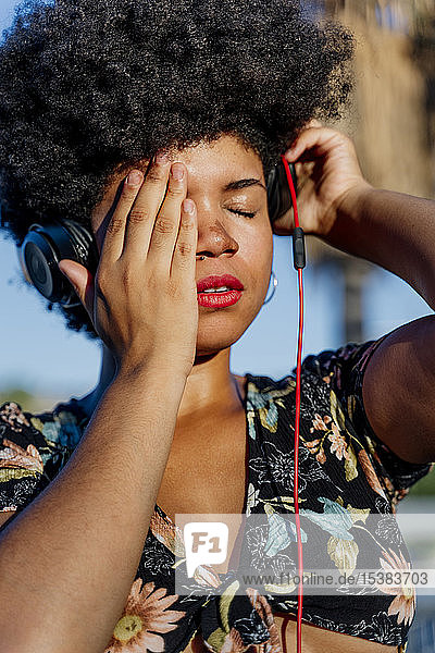 Porträt einer afroamerikanischen Frau mit Kopfhörern und geschlossenen Augen