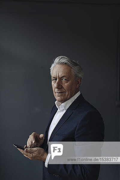 Portrait of a senior businessman holding cell phone