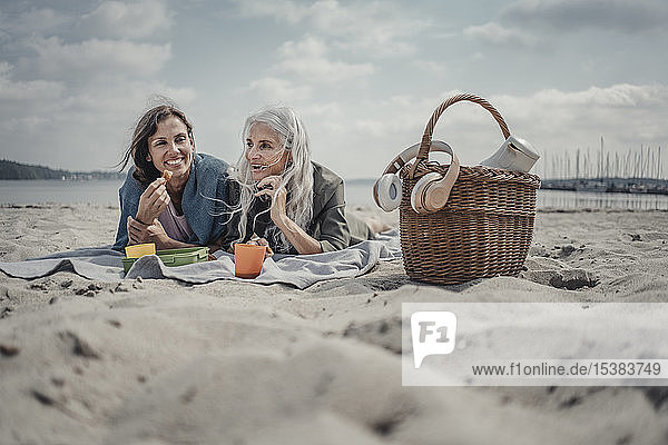 Mutter und Tochter machen ein Picknick am Strand