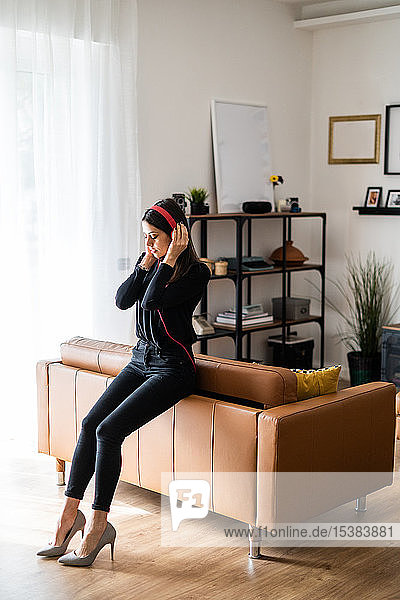 Young woman listening music with headphones at home