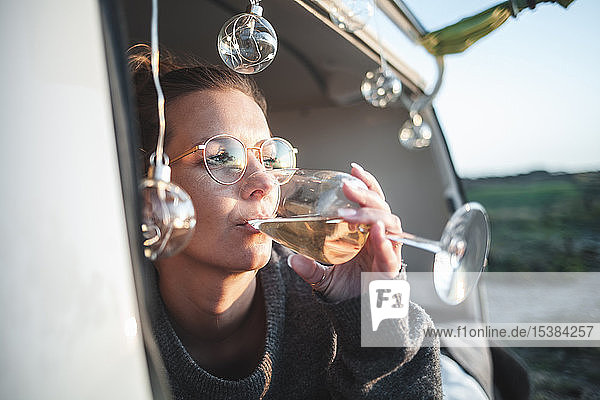 Woman with glass of white wine in van