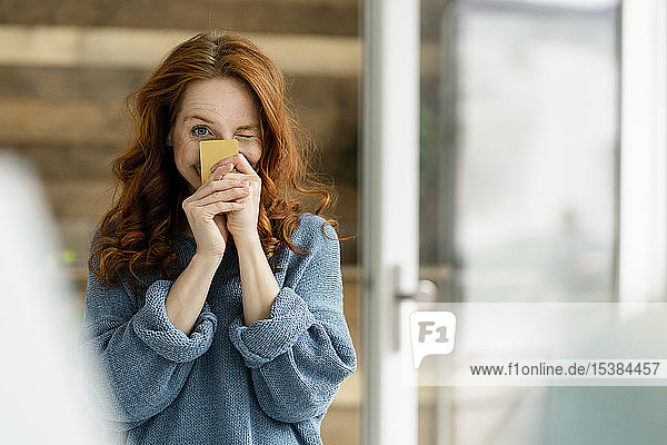 Portrait of redheaded woman with credit card in a loft