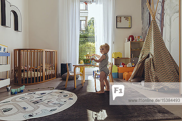 Kleiner Junge spielt in seinem Kinderzimmer