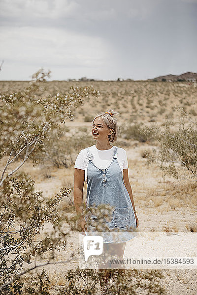 Junge Frau steht in Wüstenlandschaft  Joshua-Tree-Nationalpark  Kalifornien  USA
