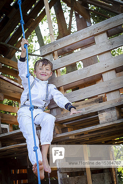 Junge als Superheld  Astronaut spielt in einem Baumhaus