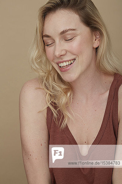 Portrait of happy blond woman wearing with eyes closed