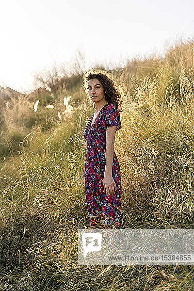 Portrait of a serious young woman  standing in meadow