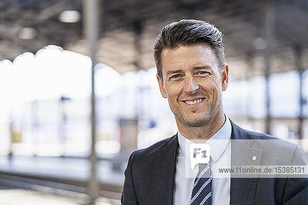 Portrait of smiling businessman at station platform
