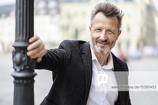 Porträt eines lächelnden reifen Geschäftsmannes mit grauem Bart