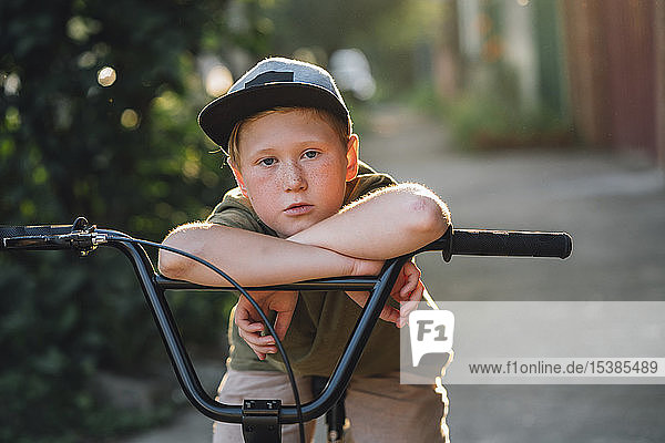 Portrait of boy with bmx bike on road