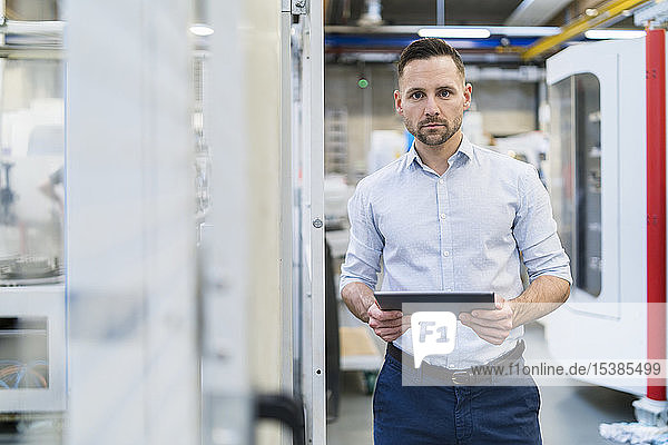 Portrait of businessman using tablet in a modern factory