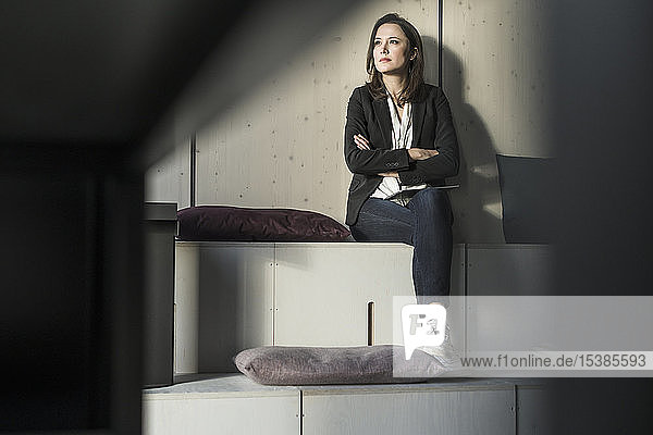 Geschäftsfrau sitzt im Lounge-Bereich im Büro