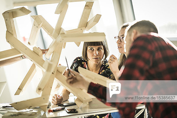 Group of creative professionals building wood object for a project
