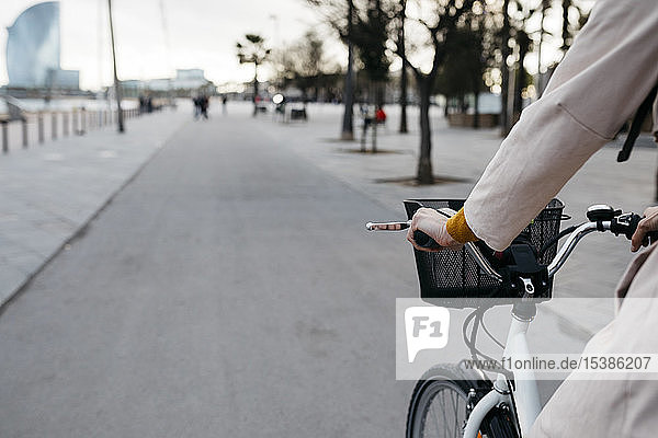 Nahaufnahme einer E-Bike fahrenden Frau auf einer Promenade