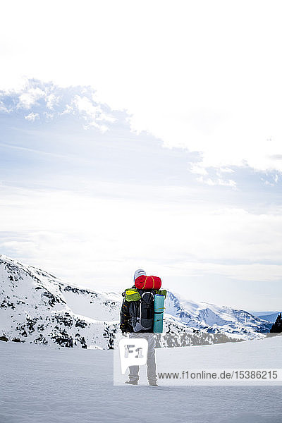 Rückansicht eines Mannes mit Rucksack  schneebedeckte Berge