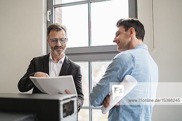 Two colleagues talking at the window in office