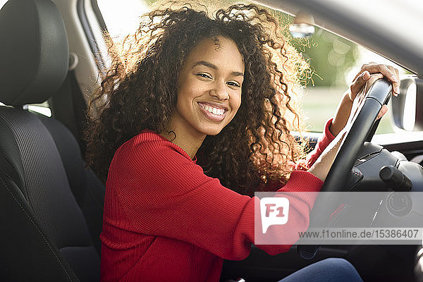 Porträt einer glücklichen jungen Frau in einem Auto