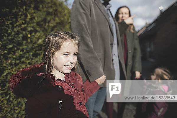 Lächelndes Mädchen hält im Freien die Hand ihres Vaters