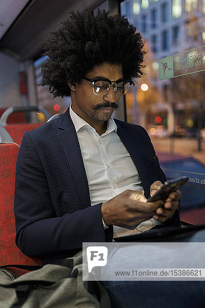 Spanien  Barcelona  Geschäftsmann nachts in der Straßenbahn mit Handy