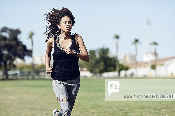 Sporty young woman with earphones running