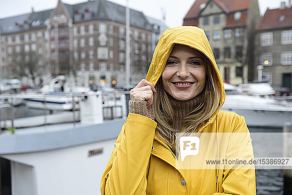Dänemark  Kopenhagen  Porträt einer glücklichen Frau im Stadthafen bei Regenwetter
