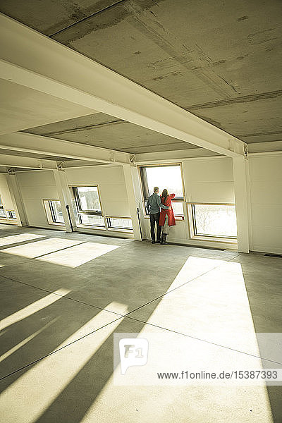 Couple looking out of window of their new home