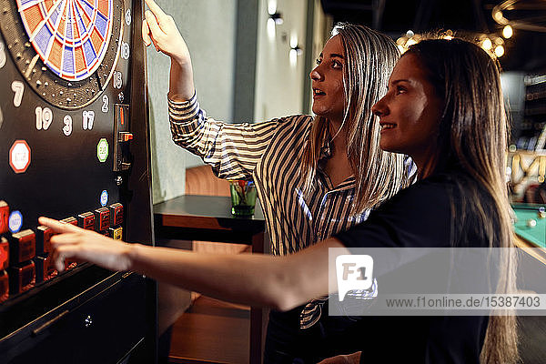 Zwei Frauen beim Dartspiel mit elektronischer Dartscheibe