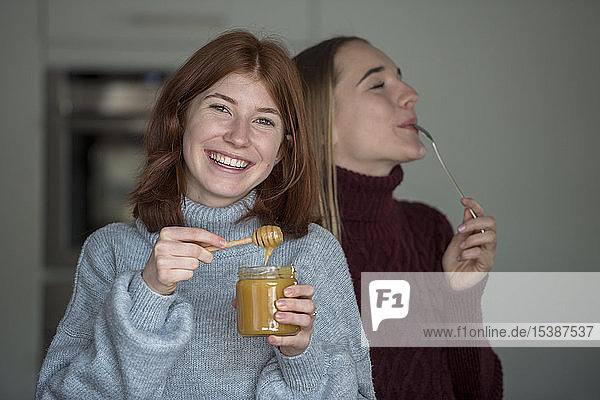 Zwei beste Freunde probieren Honig in der Küche