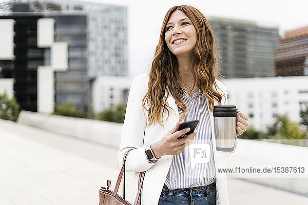 Young businesswoman commuting in the city  using smartphone