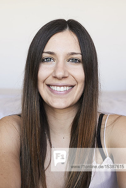Portrait of happy young woman with long brown hair