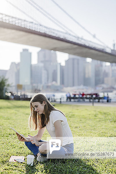 Junge Frau erkundet New York City  macht eine Pause und benutzt ein digitales Tablet
