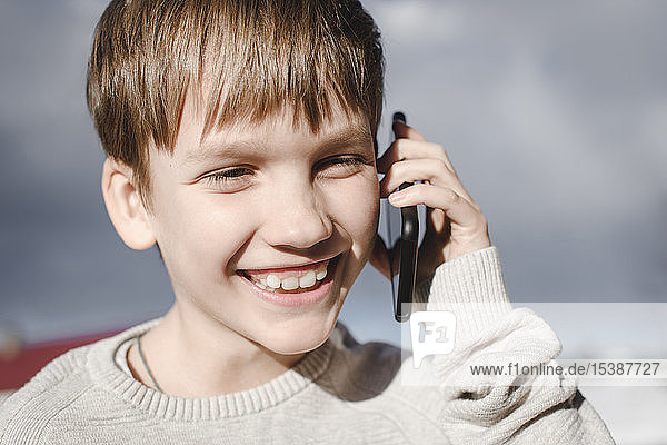 Portrait of happy boy on cell phone