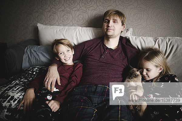 Porträt eines Vaters  zweier Kinder und einer Katze  die sich gemeinsam zu Hause entspannen