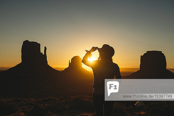 USA  Utah  Monument Valley  Silhouette einer Frau mit Cowboyhut beim Sonnenaufgang