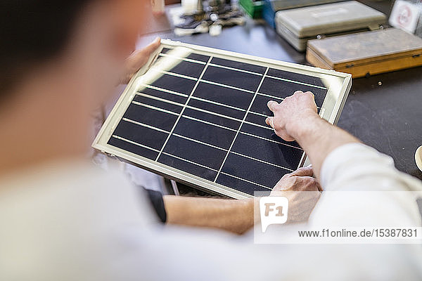 Nahaufnahme von zwei Kollegen in der Fabrik  die an der Solarzelle arbeiten