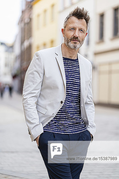 Portrait of mature man with greying beard walking in the city