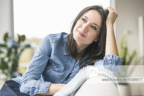 Portrait of smiling woman sitting on the couch at home