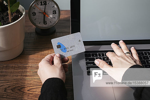 Frau benutzt Laptop und Kreditkarte für Online-Shopping  Teilansicht