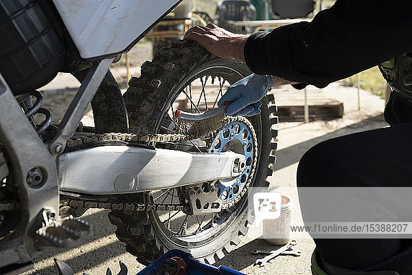 Nahaufnahme eines Mannes der am Motocross-Bike arbeitet