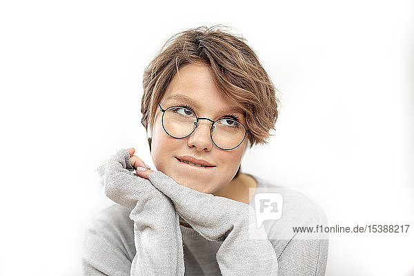 Porträt einer denkenden jungen Frau mit Brille und drahtlosen Kopfhörern