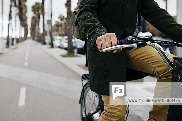 Nahaufnahme eines E-Bike fahrenden Mannes auf einer Promenade