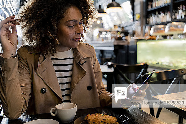 Woman using cell phone in a cafe