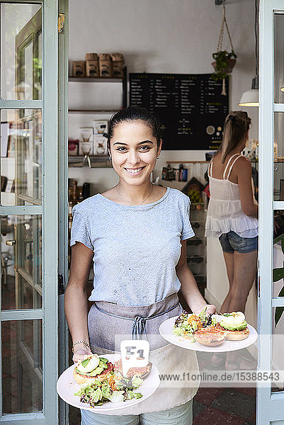 Portrait of smiling waitress serving breakfast