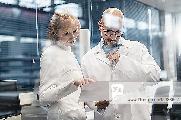 Zwei Techniker in Laborkitteln betrachten den Plan