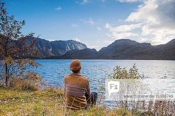Norway Lofoten Islands Storvand man sitting at the seashore