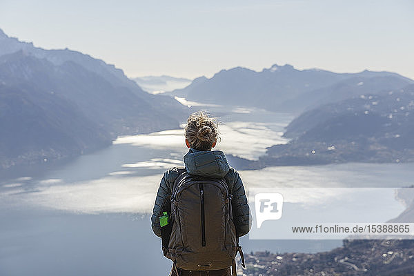 Italien  Como  Lecco  Frau auf einer Wanderung in den Bergen über dem Comer See  die die Aussicht genießt