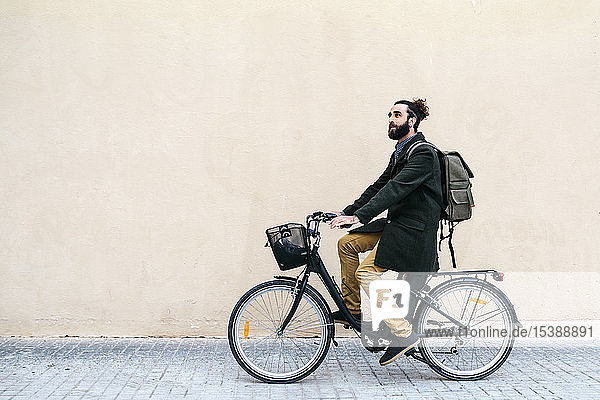 Mann fährt E-Bike entlang einer Mauer